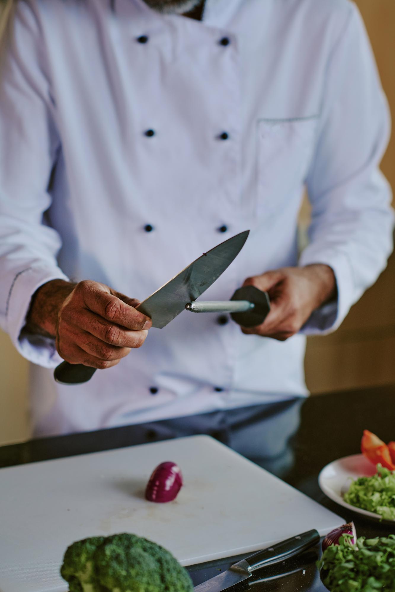 Chef che mostra una tecnica di taglio in cucina professionale